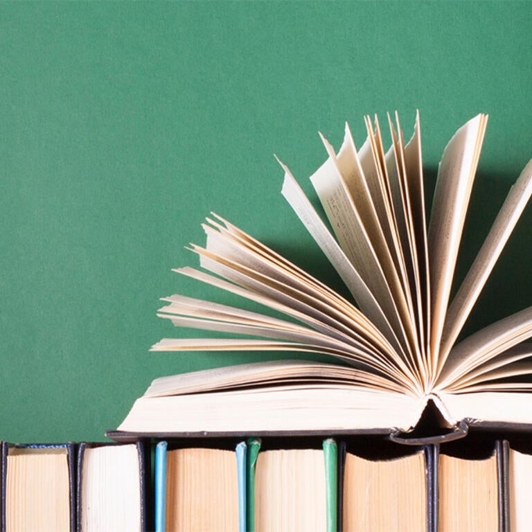 an open book on top of a row of books