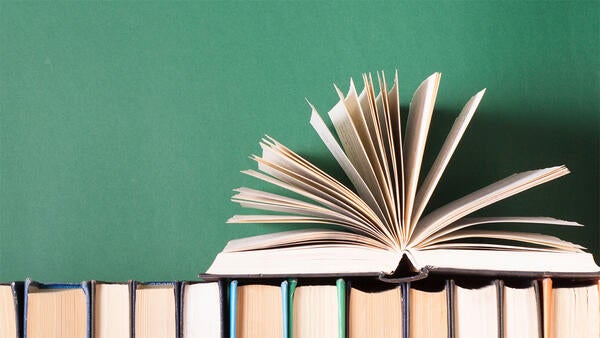 an open book on top of a row of books